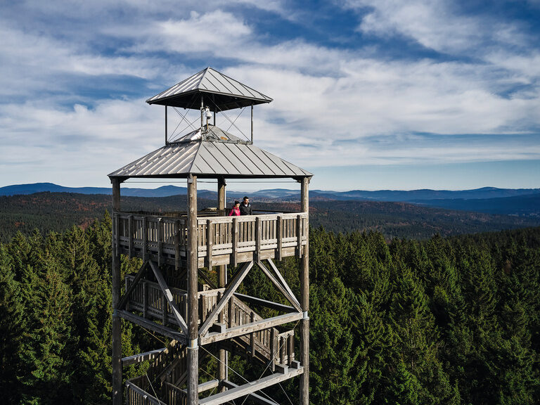 Wanderer schauen auf Sonnenuntergang im Bayerischen Wald nahe des Luxushotels Hüttenhof Menschen, von hinten gesehen, bewundern einen malerischen Sonnenuntergang im Bayerischen Wald