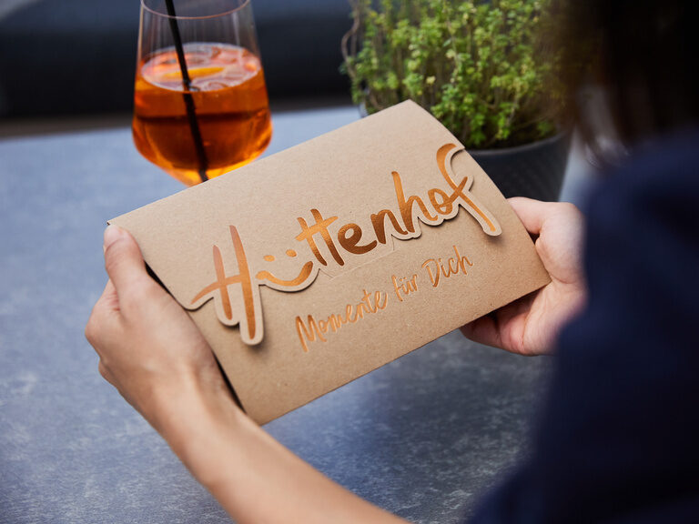 Gutschein des 4-Sterne-Wellnesshotel Hüttenhof Gutschein des Wellnesshotel Hüttenhof mit goldener Aufschrift